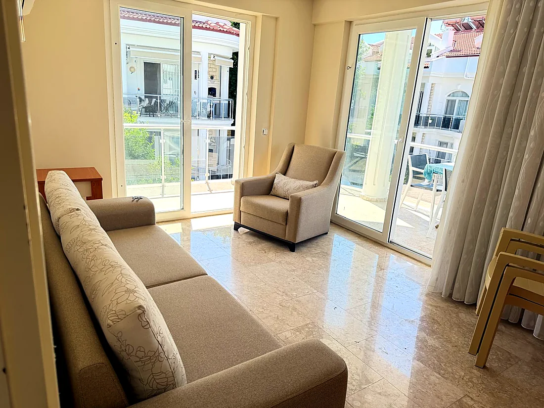 Calis Sunstay dairesinde koltuk ve balkon kapıları bulunan sofa-bed odası