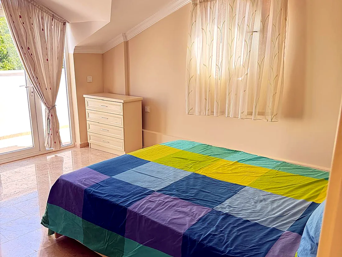 Calis Sunstay dairesinde balkon kapılı ikinci odadaki çift kişilik yatak